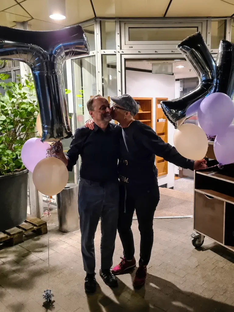 Chefin und Chef der Schreinerei Hasselwander bei der Geschenkübergabe mit Luftballons.